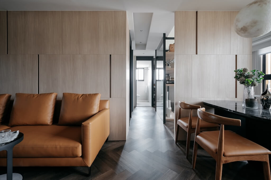 溫潤木質收納牆面搭配皮革沙發，呈現室內設計與訂製傢俱的協調氛圍