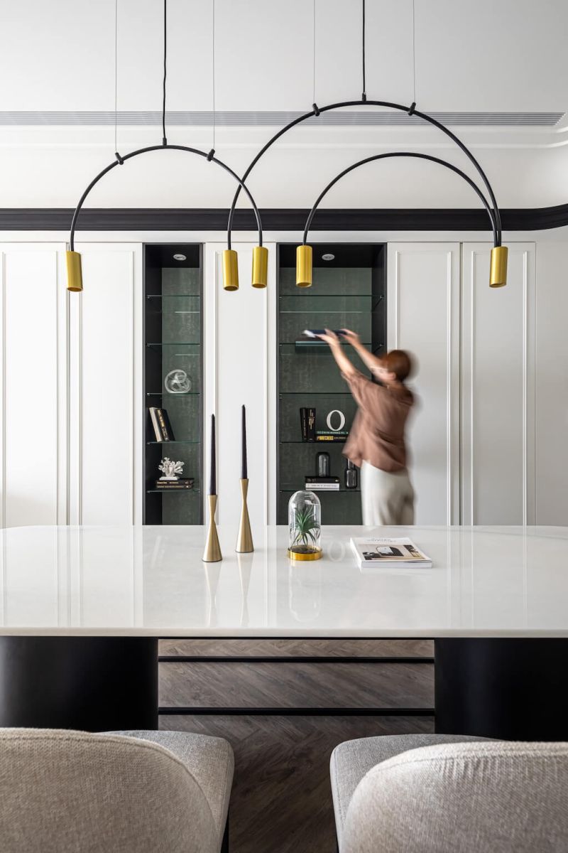 客廳訂製展示櫃設計，使用者拿取物品，強調收納習慣的重要性。